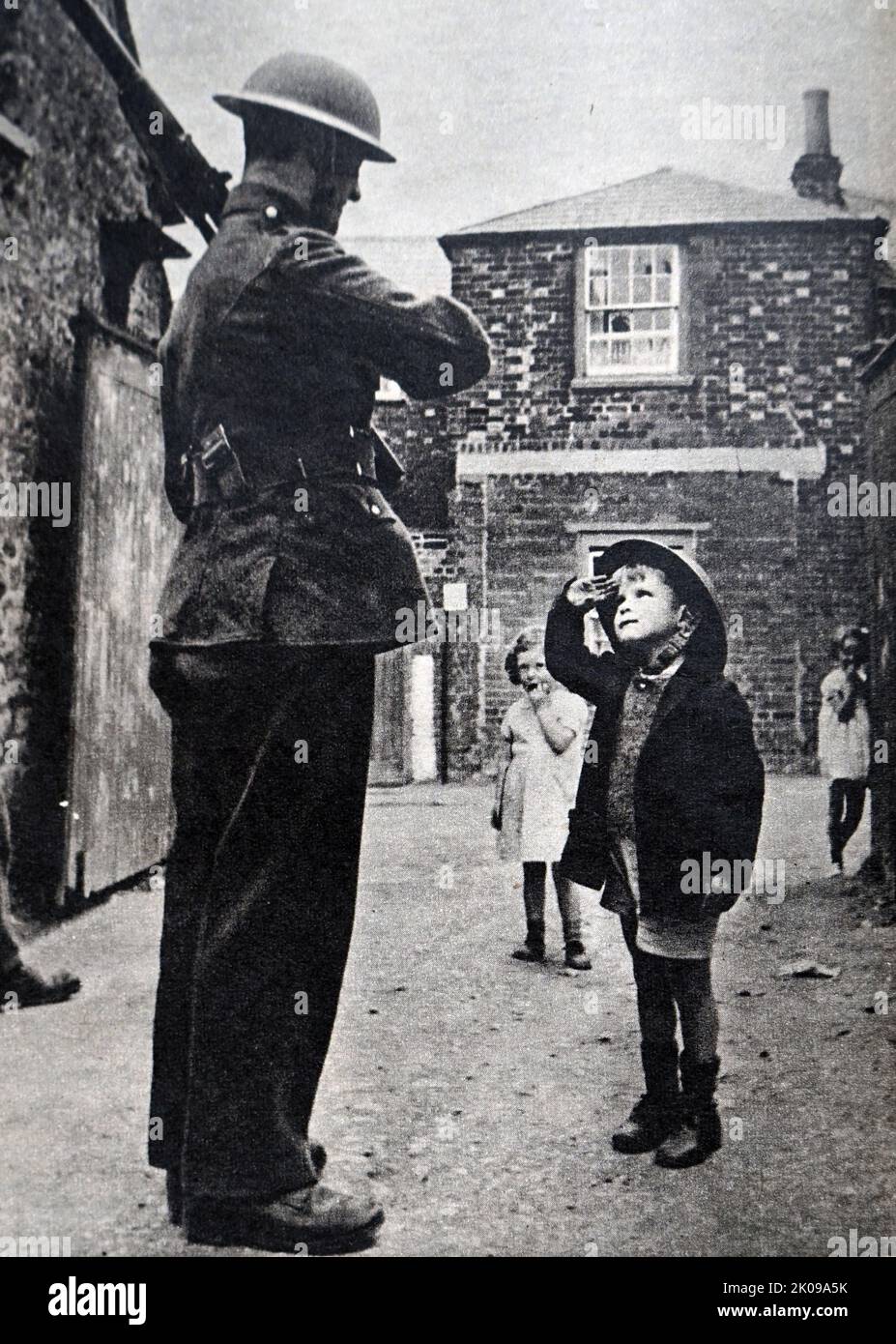 Soldato e bambino in una strada durante la seconda guerra mondiale Foto Stock