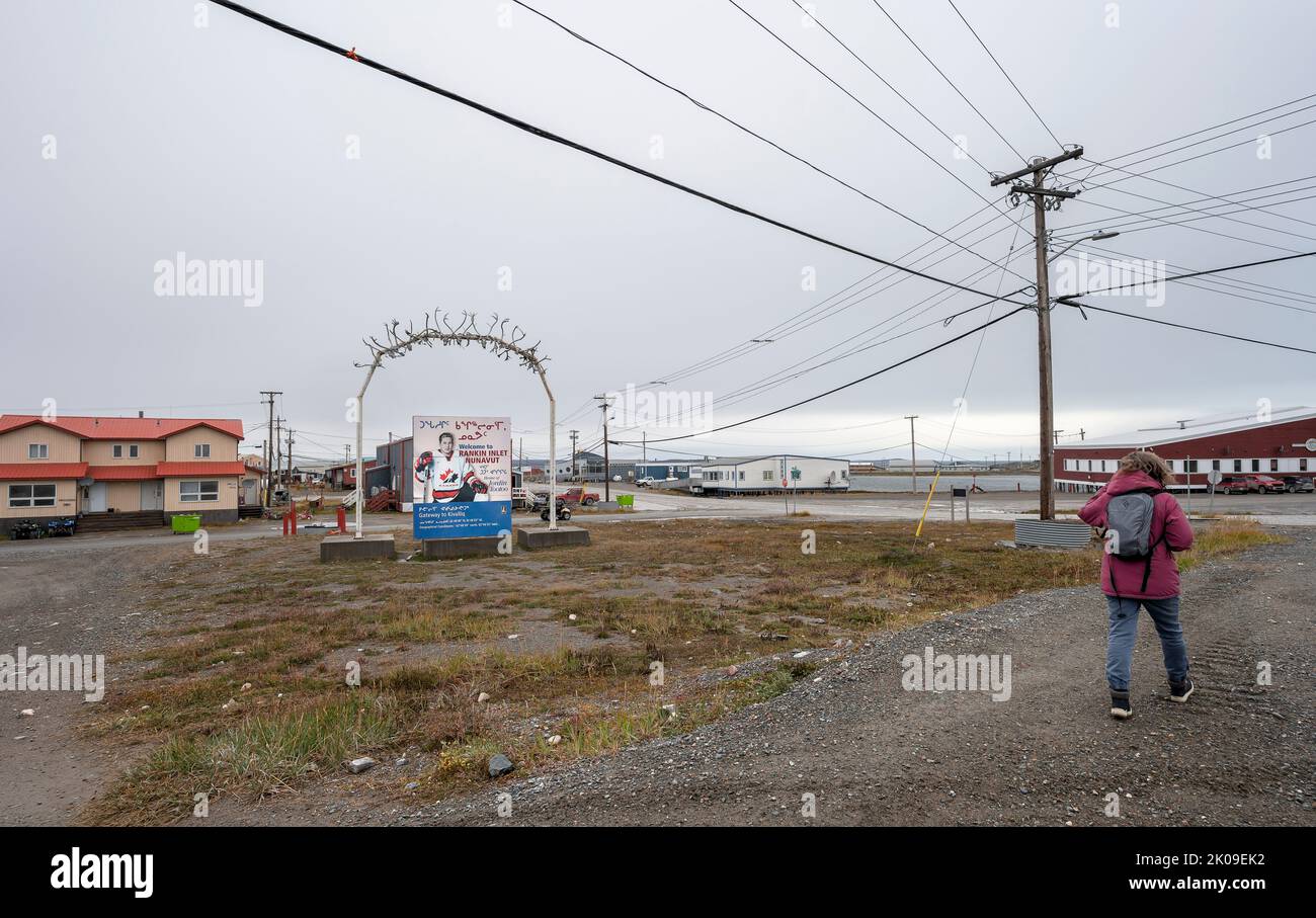 Rankin Inlet, Nunavut, Canada – 30 agosto 2022: Una persona cammina accanto al cartello d'ingresso della città con Jordin TooToo Foto Stock