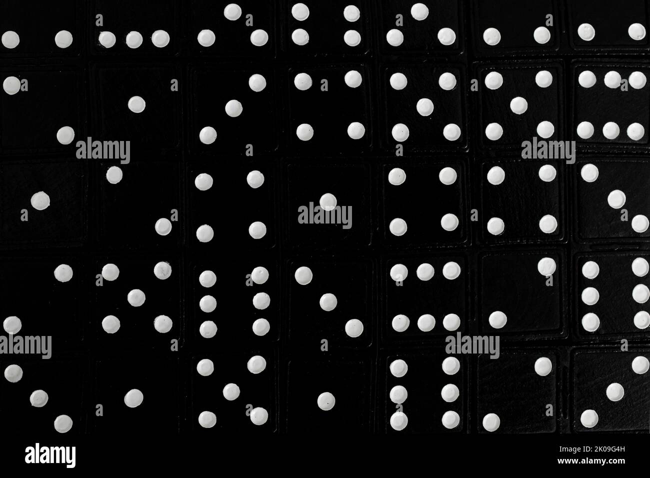 Dominali nere con punti bianchi, sfondo a cornice intera. Sfondo solido astratto. Ordine casuale. Foto Stock