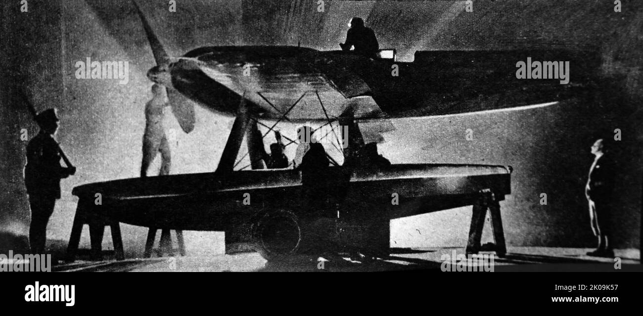 Sotto una guardia militare, i tecnici lavorano sul Supermarine S.6, sotto la supervisione di R.J. Mitchell. Il Supermarine S.6 era un idrovolante da corsa a singolo sedile britannico del 1920s costruito da Supermarine. La S.6 ha continuato la linea di piloti di idrovolanti Supermarine progettati per i concorsi Schneider Trophy della fine degli anni '1920 e '1930s. Reginald Joseph Mitchell CBE (FRAeS, 20 maggio 1895 1936 – 11 giugno 1937) è stato un . È meglio ricordato per la progettazione di idrovolanti da corsa come il Supermarine S.6B, e. Foto Stock