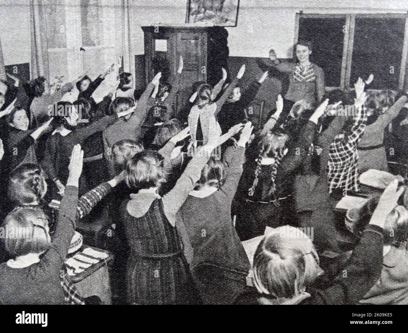 I bambini della scuola tedesca che eseguono il saluto nazista. La Germania nazista, ufficialmente conosciuta come il Reich tedesco dal 1933 al 1943, e il Grande Reich tedesco dal 1943 al 1945, fu lo Stato tedesco tra il 1933 e il 1945, quando Adolf Hitler e il Partito nazista controllavano il paese, trasformandolo in una dittatura. Foto Stock