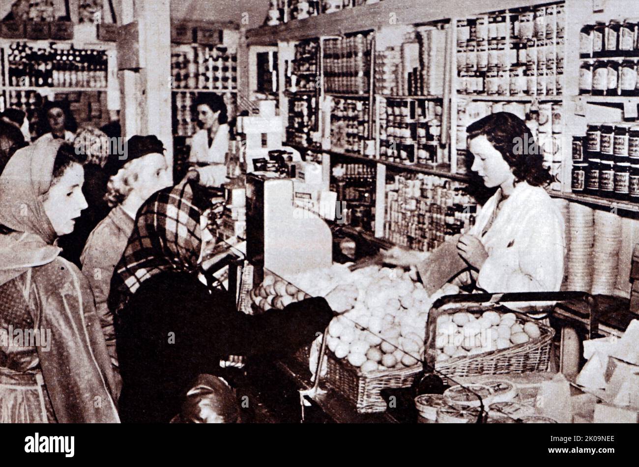 Acquirenti che comprano uova in un negozio in Inghilterra durante la seconda guerra mondiale Foto Stock