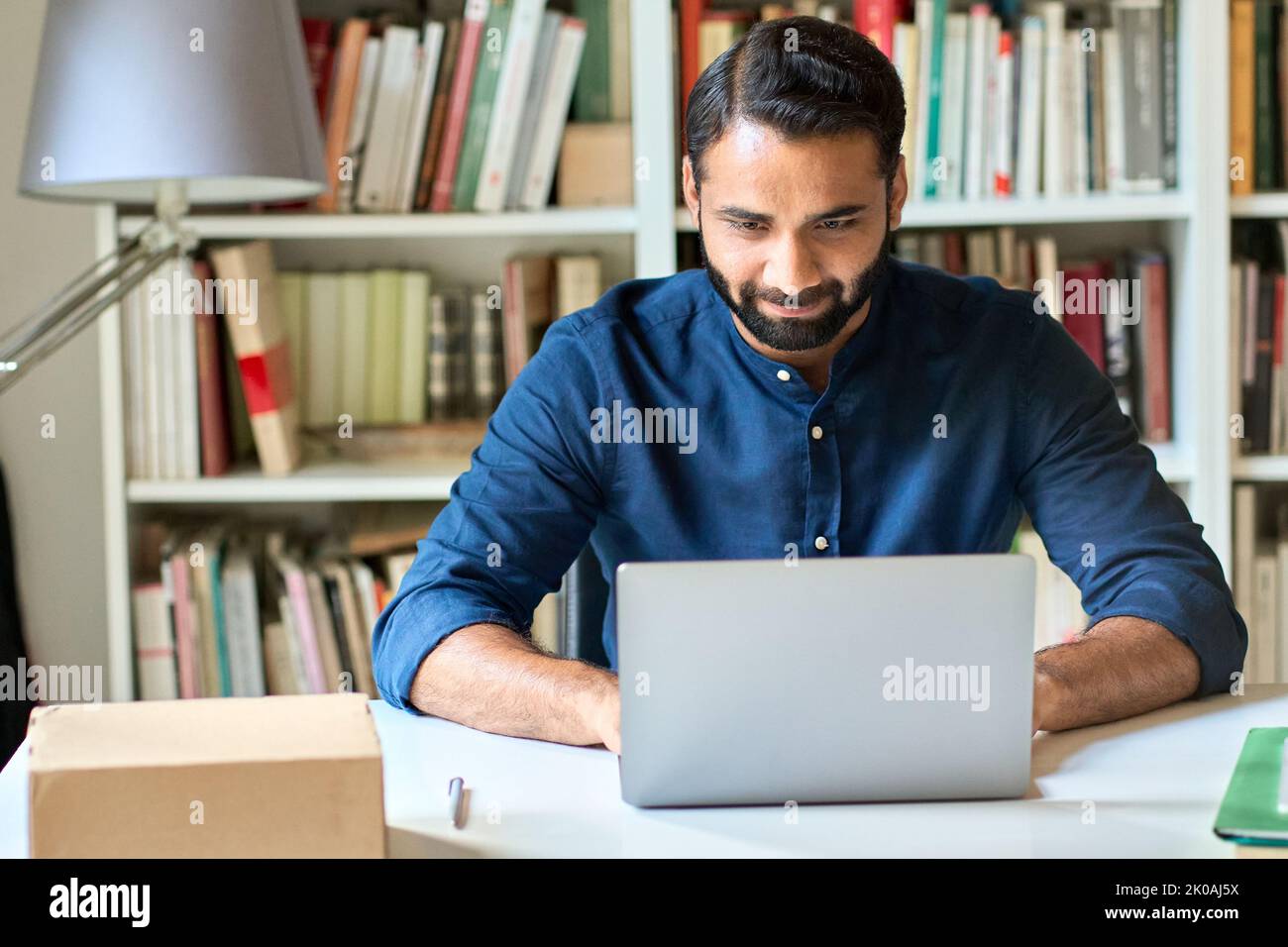 Uomo d'affari indiano professionale di lavoro o di apprendimento aziendale su un computer portatile. Foto Stock