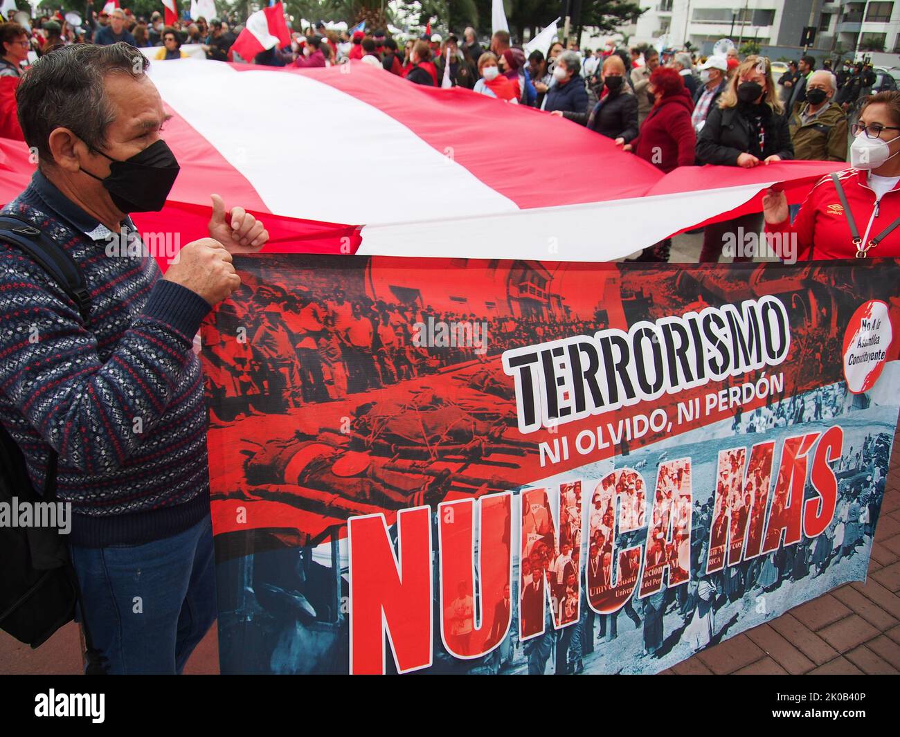 "Terrorismo mai più” può essere letto su un banner quando centinaia di persone si riuniscono per le strade per celebrare il 30th° anniversario della cattura e il primo anniversario della morte di Abimael Guzman, leader del gruppo terroristico Shining Path. Guzman (86) fu catturato il 12th settembre 1992 e morì nella prigione di base di Callao Naval il 11th settembre 2021, dove stava servendo una condanna a vita per atti terroristici che devastarono il paese negli anni '1980s e '1990s. Foto Stock
