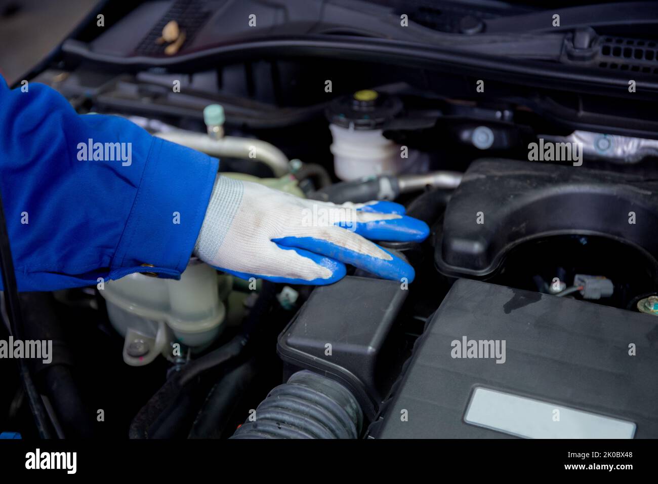Mani di primo piano di uomo è meccanico riparazione motore di auto in garage, auto servizio, lavoratore fisso e la regolazione parte di automobile con problemi nel Foto Stock