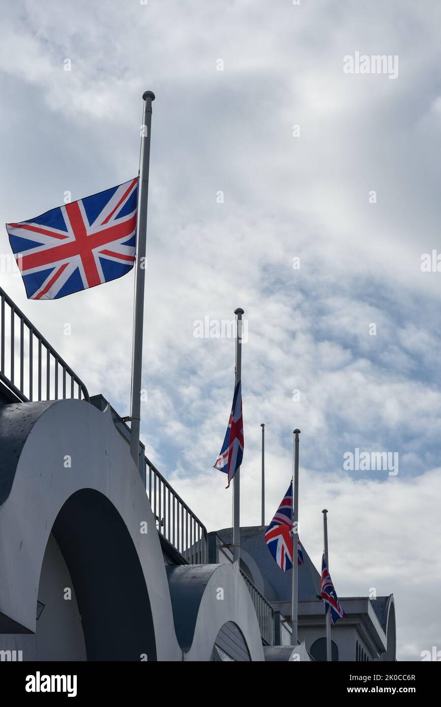 Union Jack bandiere battenti a metà albero come un gesto di rispetto per la morte della regina Elisabetta 2nd. Queste bandiere si trovano sul South Parade Pier a Portsmouth, Foto Stock