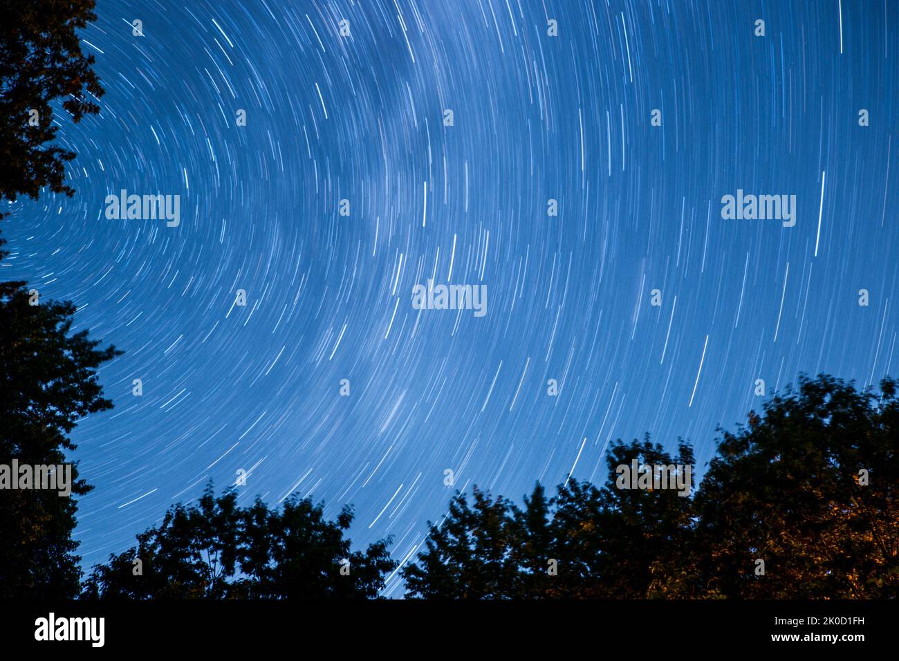 Un cielo blu notturno con sentieri a luci stellari Foto Stock