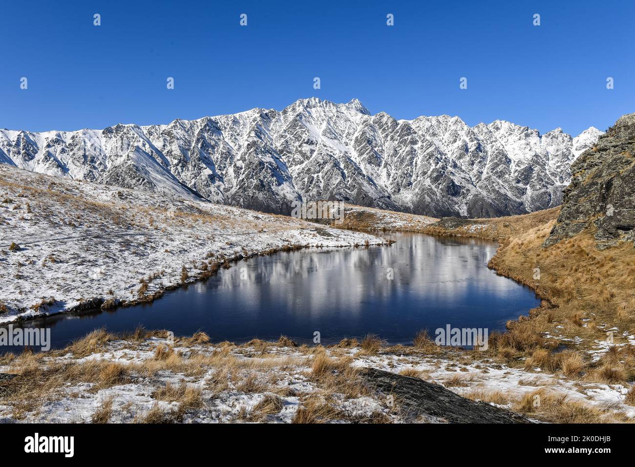 Il Remarkables riflessa in vetta Tarn Deer Park Heights vicino a Queenstown Isola del Sud della Nuova Zelanda Foto Stock