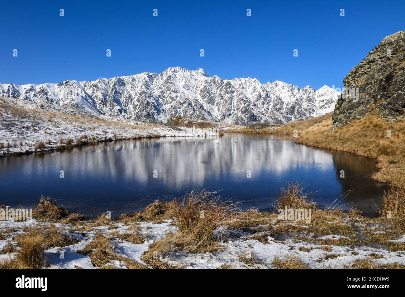 Il Remarkables riflessa in vetta Tarn Deer Park Heights vicino a Queenstown Isola del Sud della Nuova Zelanda Foto Stock