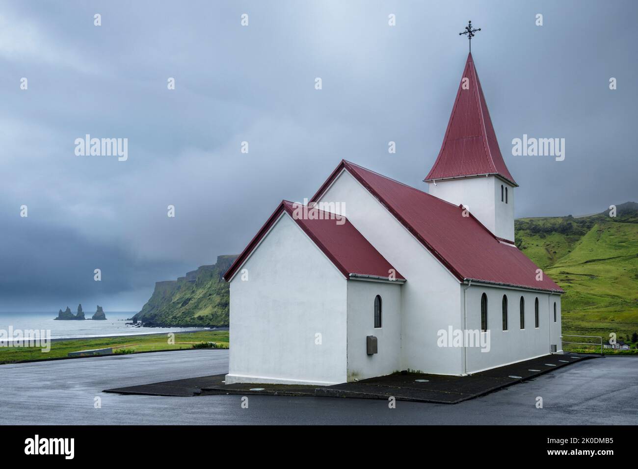 Vik i Myrdal Chiesa e vista verso le formazioni rocciose a Reynisfjara, Vik, Islanda Foto Stock