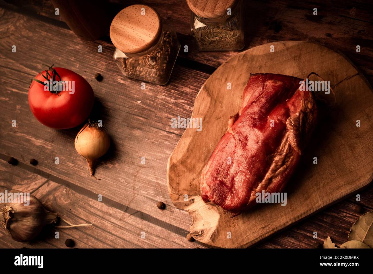 Carne su un tavolo di legno con aggiunta di erbe fresche e spezie aromatiche. Prodotto naturale di fattoria biologica, prodotto con metodi tradizionali Foto Stock