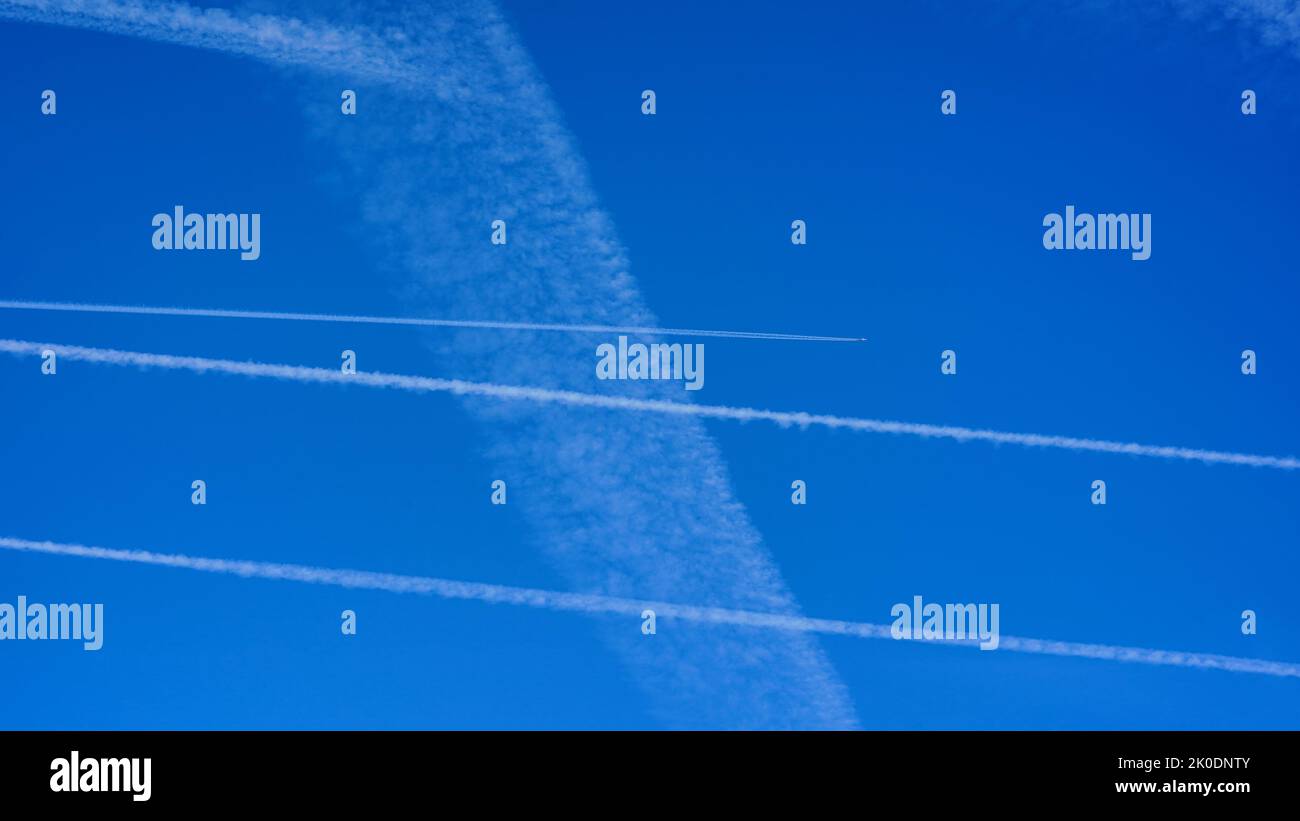 Cielo blu con piste di condensazione per aerei. Foto Stock