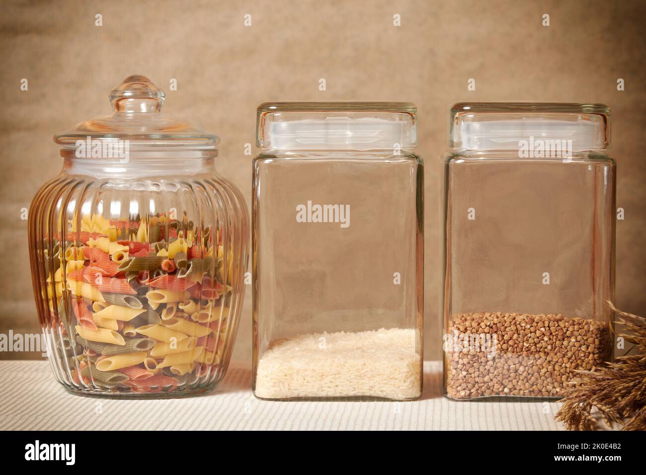 Grano saraceno, riso, pasta colorata, cereali per porridge e colazione. Tavolo da cucina e accessori Foto Stock