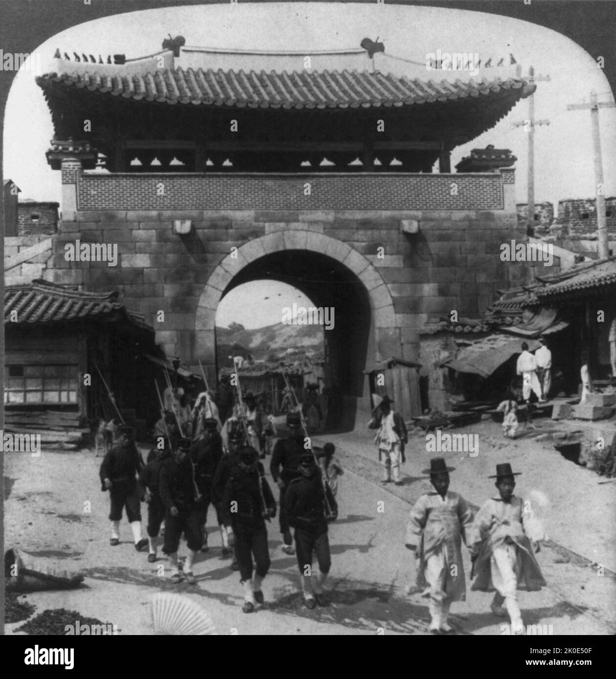 Vista della porta di Donuimun, Seoul, Corea, che mostra le rotaie elettriche del tram e i pali del telegrafo. Joseon Dynasty Korea, 1900. Foto Stock