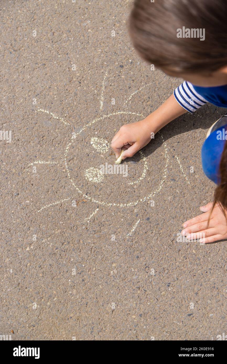 I bambini disegnano sul marciapiede con gesso. Fuoco selettivo. Natura. Foto Stock