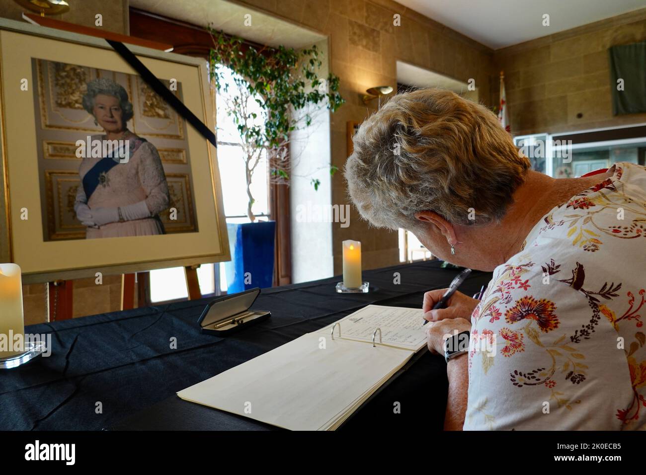 Exeter, Devon, Regno Unito. 11th Set, 2022. Membro del pubblico che firma il Libro delle condoglianze per sua Maestà la Regina Elisabetta II, nella County Hall Exeter. Credit: Julian Kemp/Alamy Live News Foto Stock