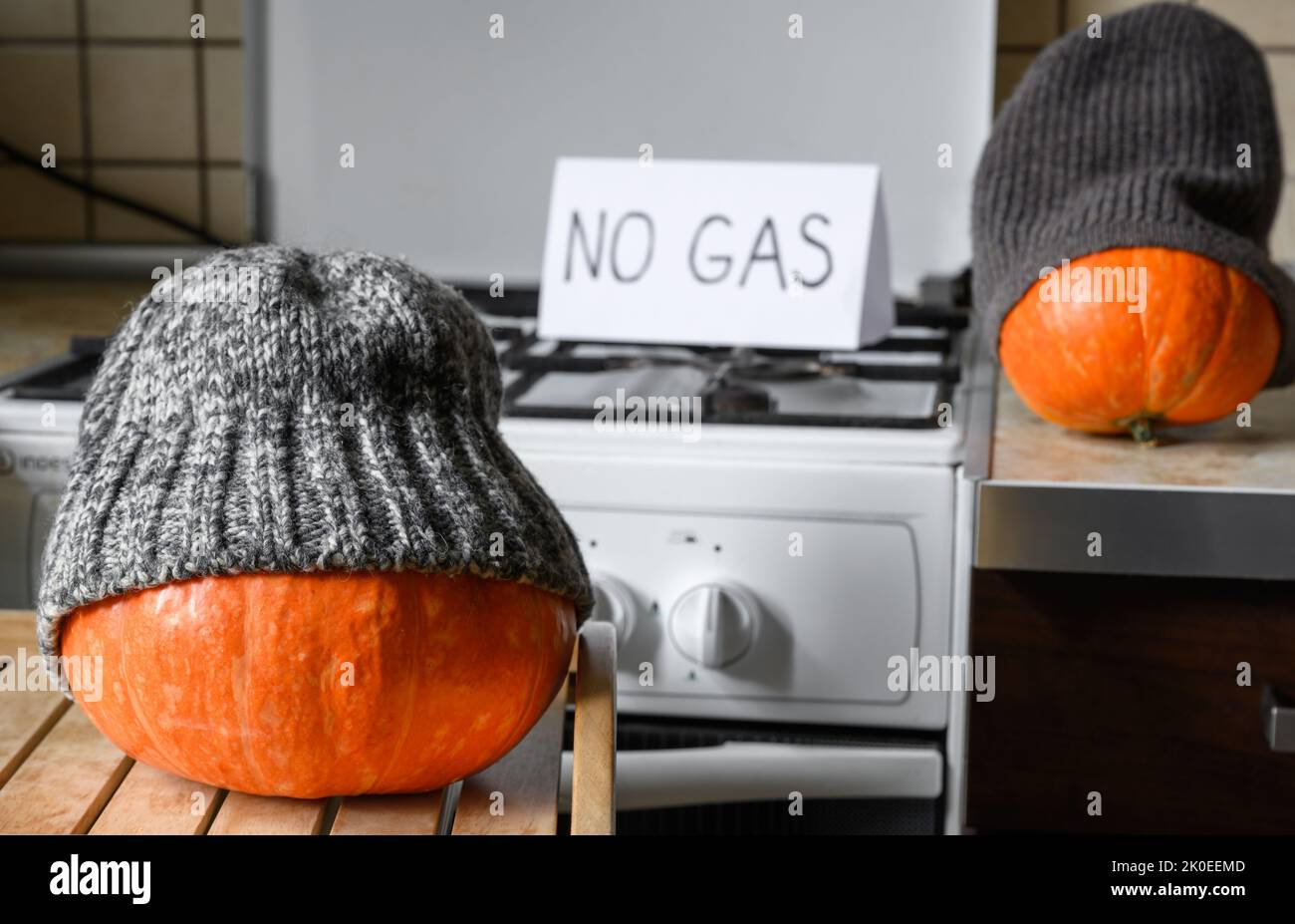 Zucche in cappelli di inverno su Halloween a casa fredda, senza gas ed elettricità per il riscaldamento, le verdure divertenti sono congelate. Crisi energetica, costo costoso, tha Foto Stock