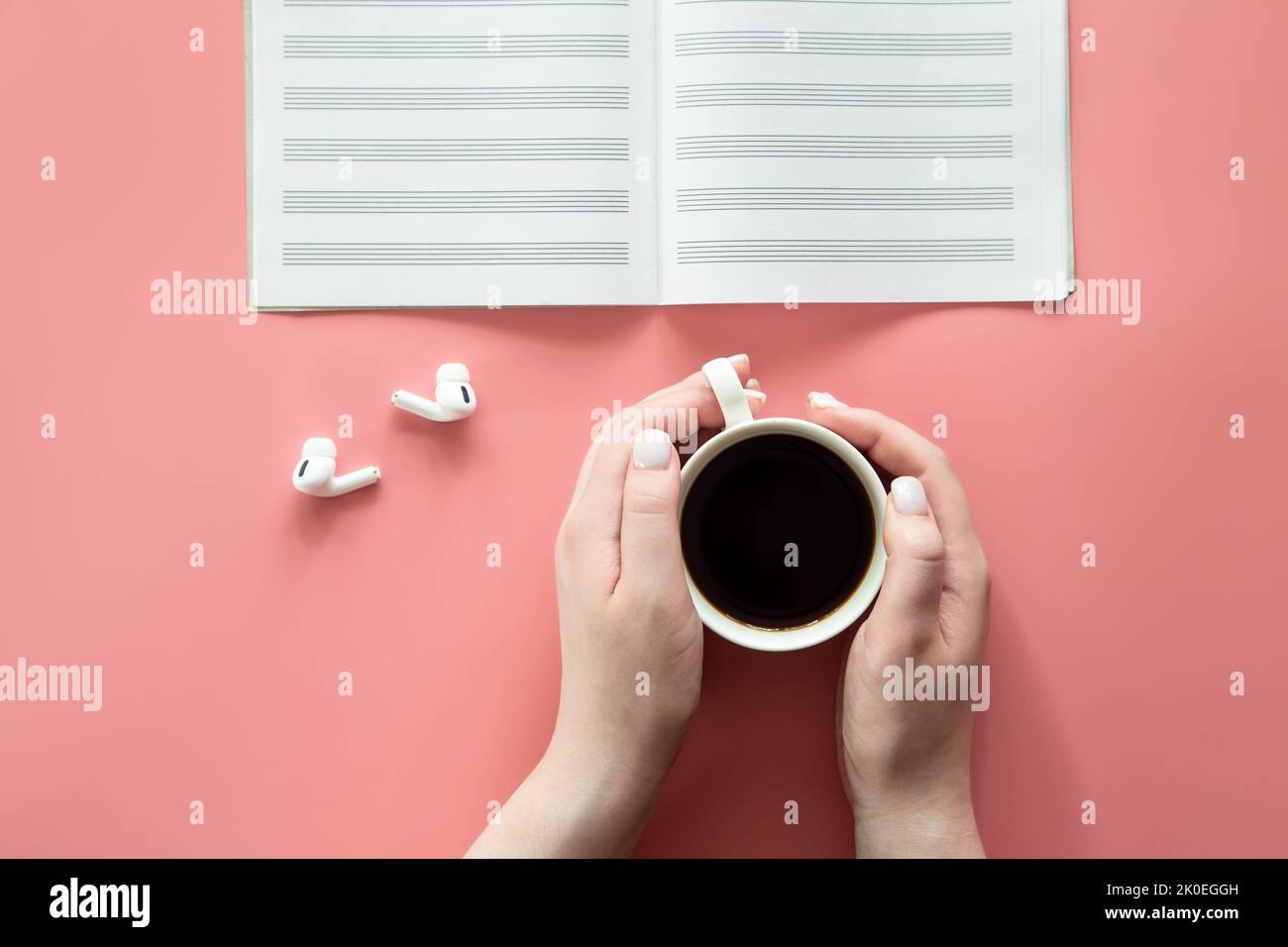 Quaderno per scrivere appunti e una tazza di caffè su sfondo rosa, piatto. Foto Stock