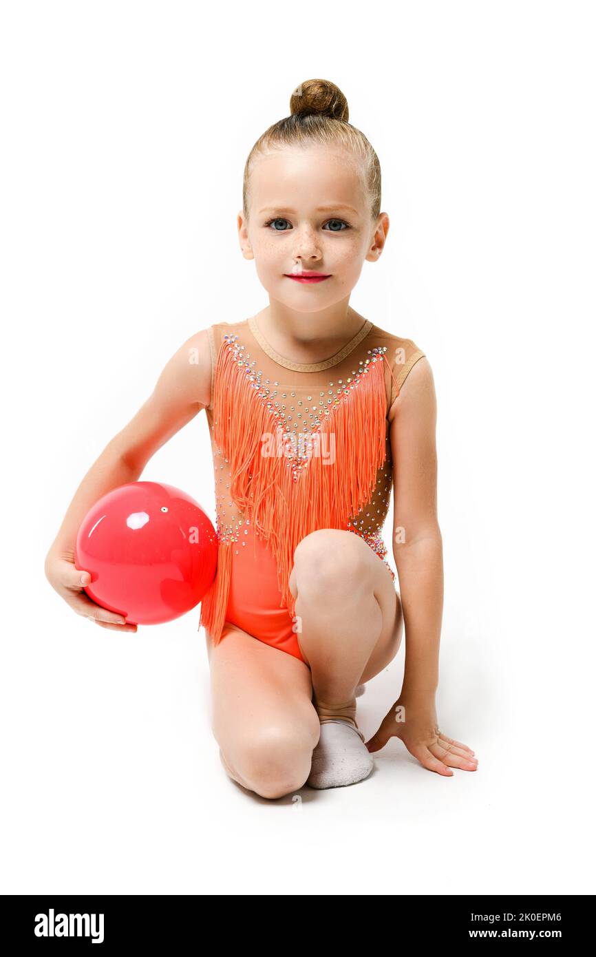 Piccola ragazza ginnastica studio ritratto con palla di gomma, acrobazie artistiche e sport professionale per i bambini. La ragazza si siede su un ginocchio. Foto Stock