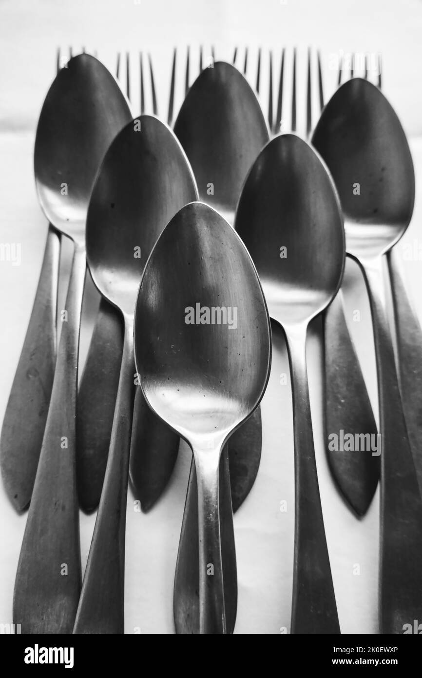 Foto in bianco e nero con cucchiai disposti su forchette Foto Stock