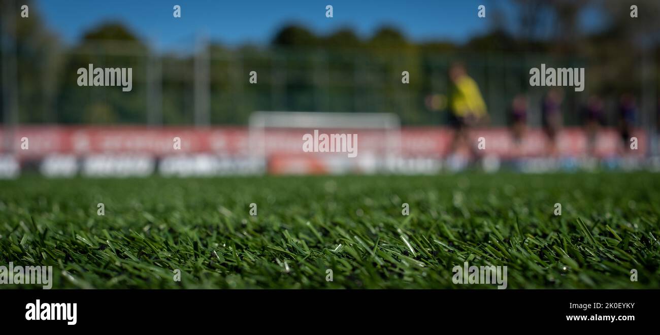 Calcio sfondo con verde erba spazio per la copia e fuori fuoco squadre anonime schierate nella parte posteriore. Sfondo banner torneo di calcio. Foto Stock