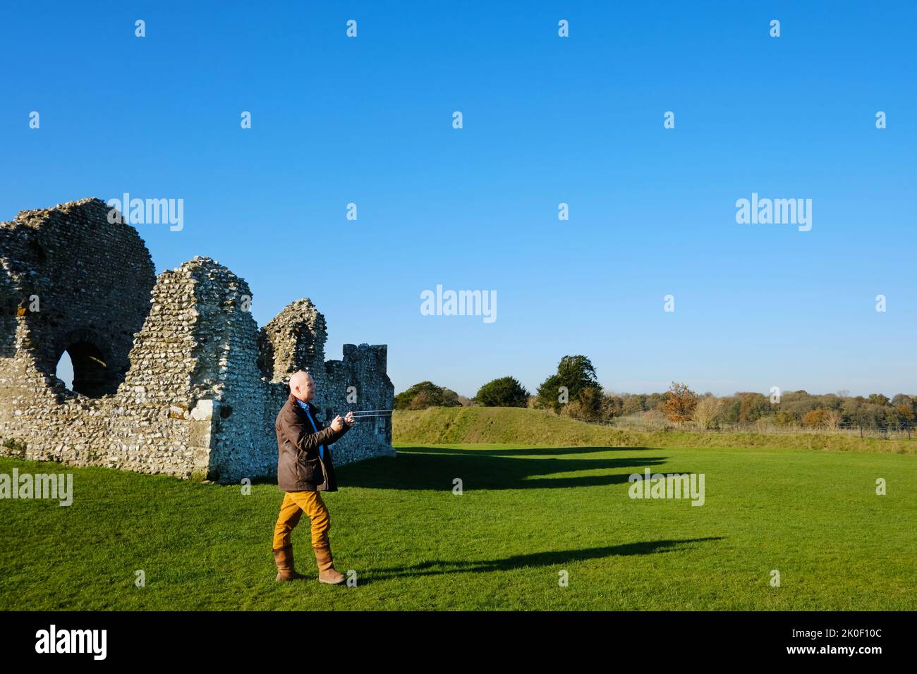Maschio adulto che dowsing le linee del ley alla chiesa di Knowlton, Dorset, Regno Unito - John Gollop Foto Stock