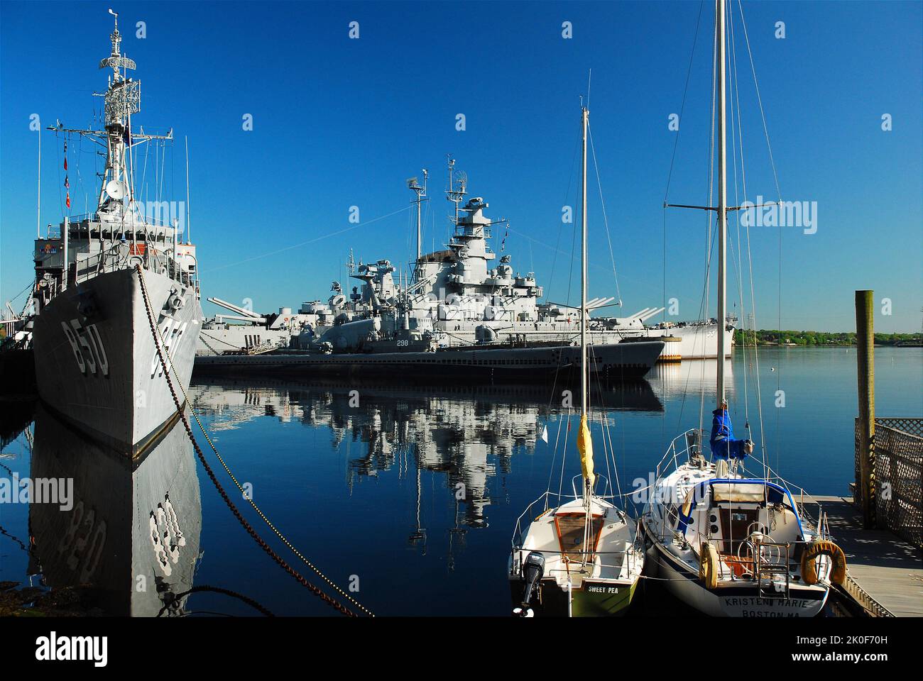 La nave da guerra USS Massachusetts e il cacciatorpediniere USS Joseph P Kennedy sono riflessi in lui ancora acqua di Fall River Foto Stock