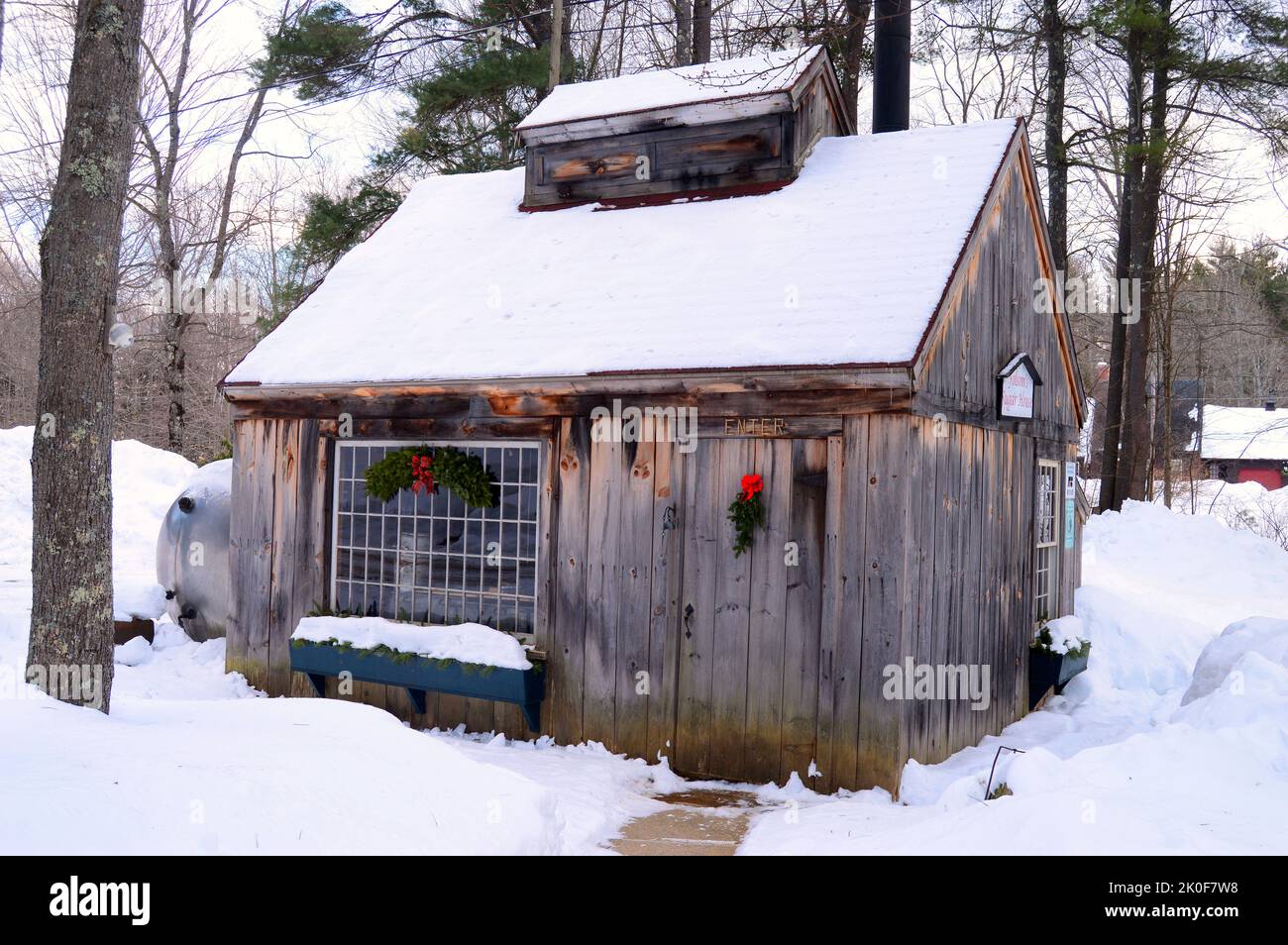 La Folsom Sugar House è coperta da una coperta di neve ed è decorata per le vacanze di Natale nel New Hampshire Foto Stock