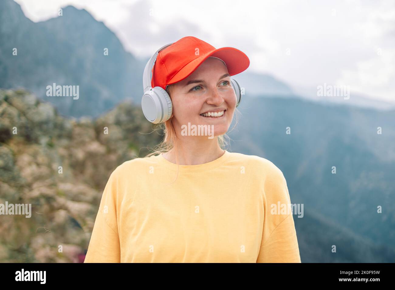 Felice donna turista ascolta la musica sulla cima della montagna Tatry, mentre escursioni a piedi viaggio naturale paesaggio di montagna all'aperto. Foto Stock