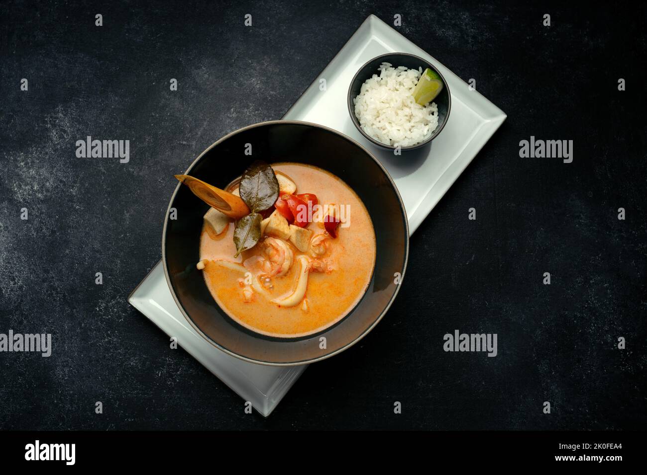 Zuppa tailandese con pesce, su cemento scuro Foto Stock