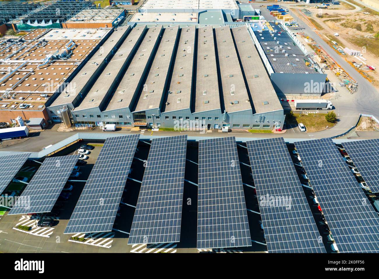 Vista aerea dei pannelli solari installati sul parcheggio con auto parcheggiate per una generazione efficace di energia pulita Foto Stock