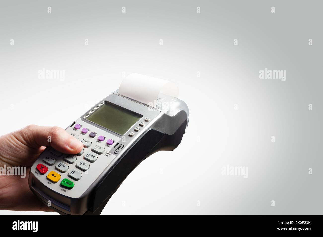 Cash terminal in mano di un uomo su sfondo bianco. Acquisti all'ingrosso e al dettaglio, vendite, carte bancarie e di credito, servizi. Minimalismo. C'è f Foto Stock