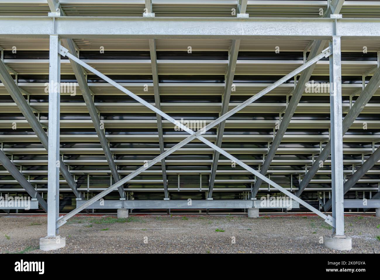 Diritto sulla vista dei bleacher sotto lo stadio, rubare i-Beam bleacher con X croce parentesi, con superficie in pietra. Posizione non descrittiva senza persone. Foto Stock
