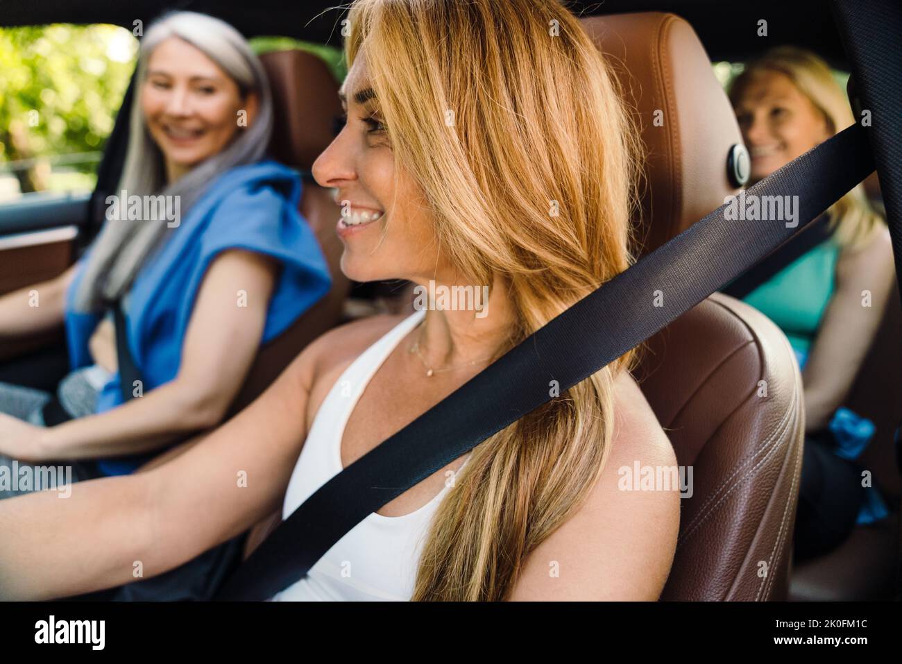 Donne multirazziali ridere e parlare in auto dopo la pratica di yoga Foto Stock
