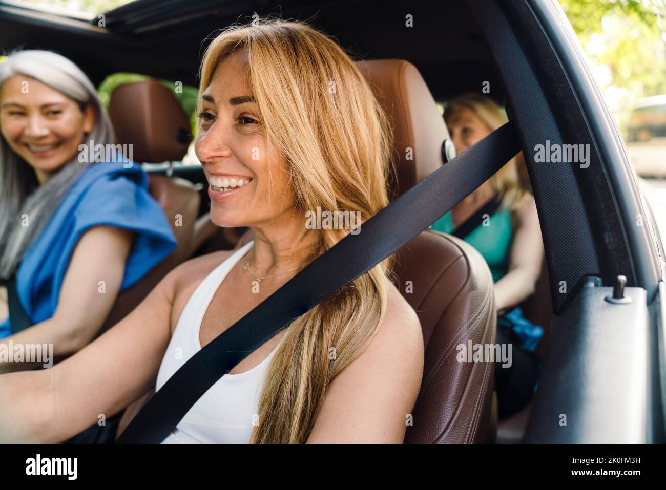 Donne multirazziali ridere e parlare in auto dopo la pratica di yoga Foto Stock