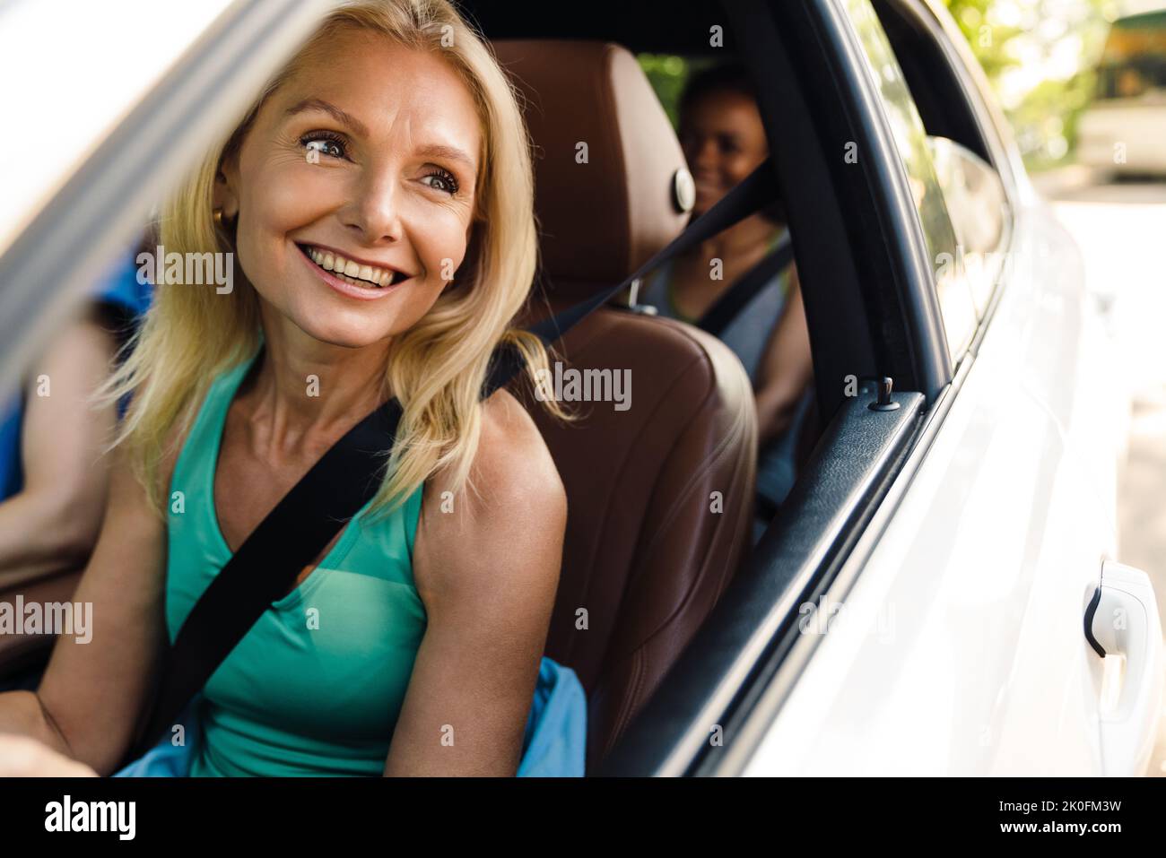 Donne multirazziali ridere e parlare in auto dopo la pratica di yoga Foto Stock