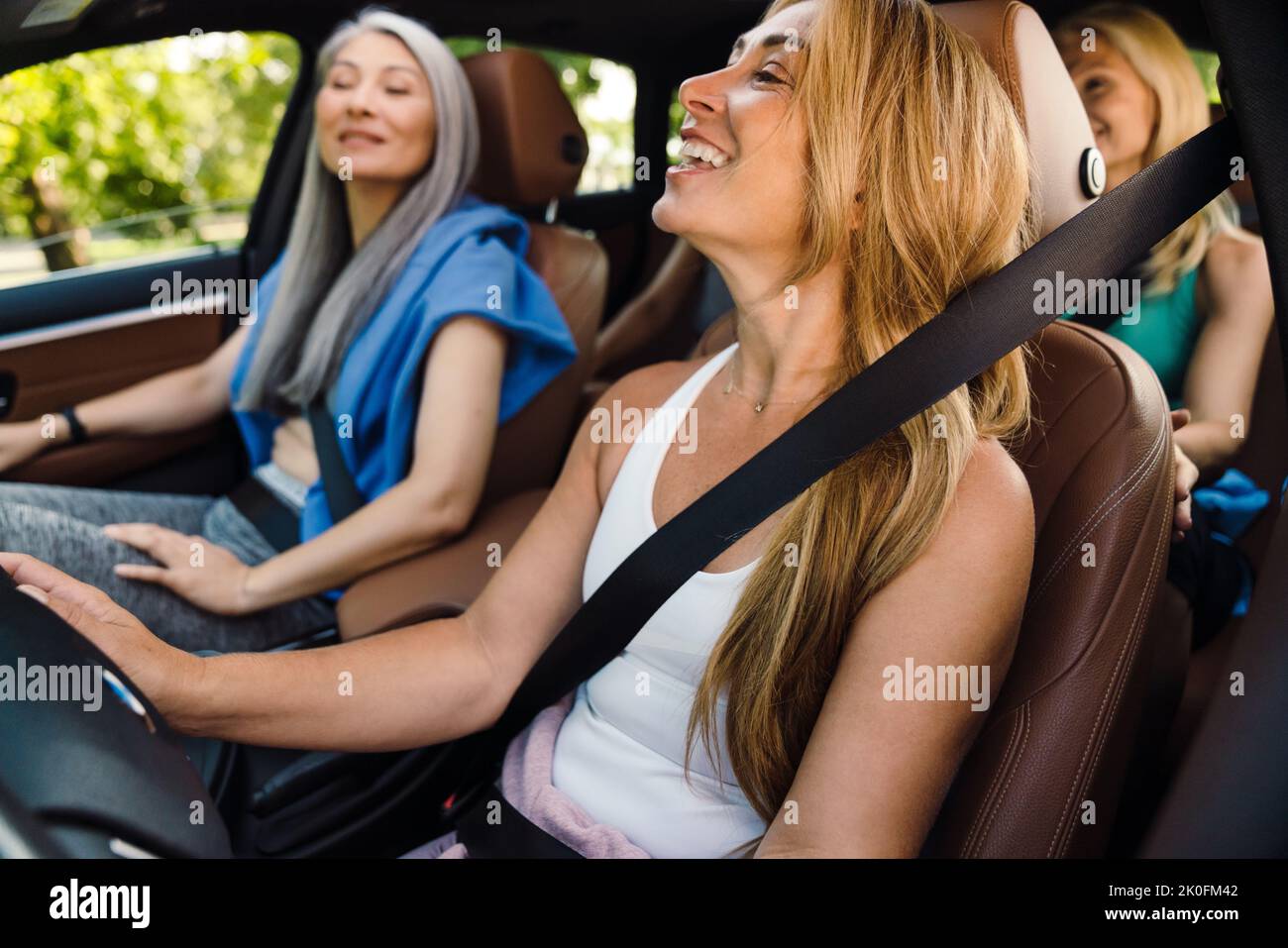 Donne multirazziali ridere e parlare in auto dopo la pratica di yoga Foto Stock