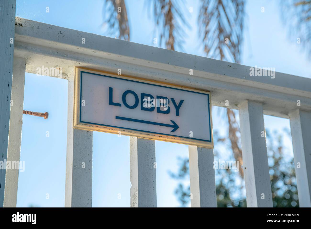 La Jolla, California- direzione della lobby con una freccia che punta a destra. Segnaletica su ringhiere di legno dipinte contro la palma l Foto Stock