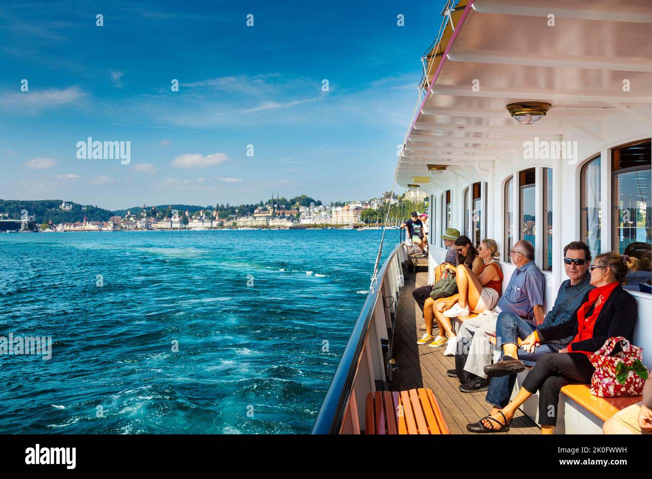Persone che si godono un giro in barca a vapore sul lago di Lucerna con la città sullo sfondo, Lucerna, Svizzera Foto Stock
