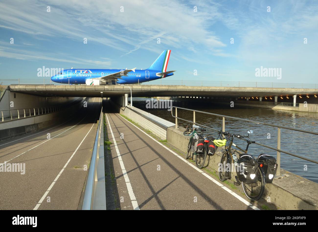 Un aereo che attraversa un ponte su un canale e una strada all'aeroporto Schipol di Amsterdam, Paesi Bassi Foto Stock