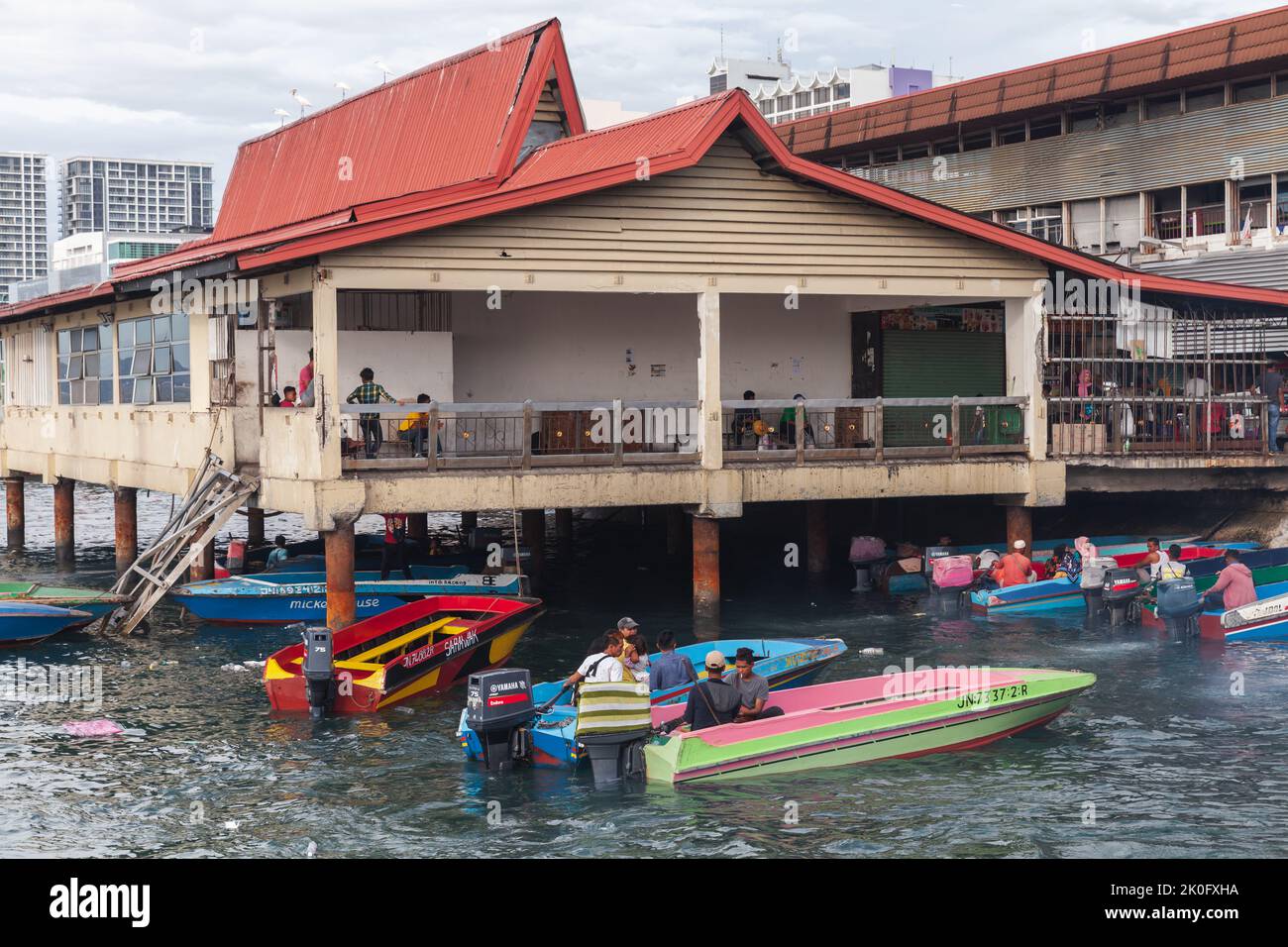 Kota Kinabalu, Malesia - 23 marzo 2019: Barche a motore con equipaggio e passeggeri sono ormeggiati al KK Fish Market in una giornata di sole, a buon mercato dei trasporti pubblici tra Foto Stock