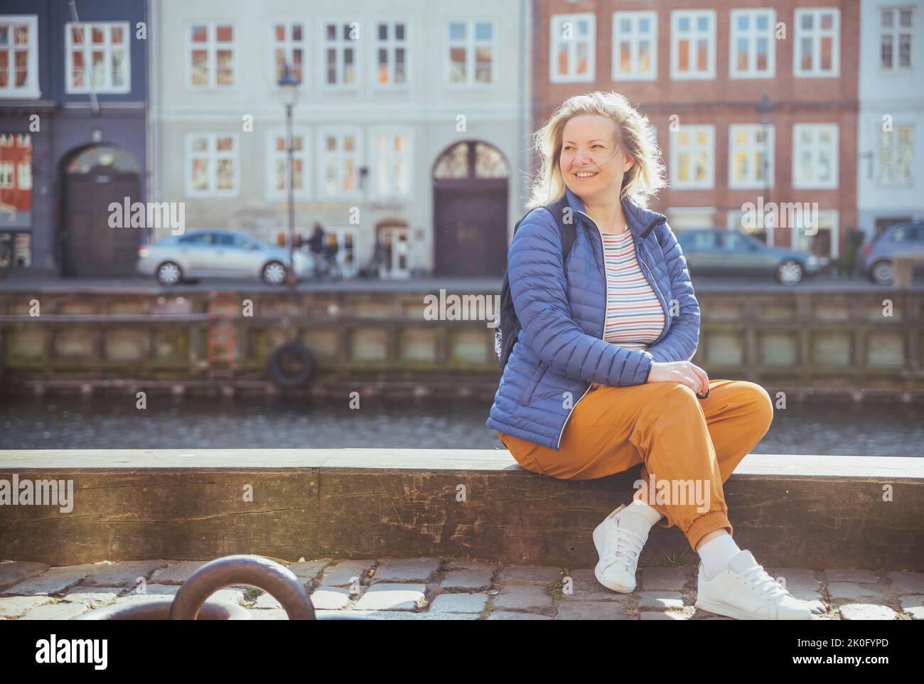 Ragazza bionda che si rilassa sul lungomare di Nyhavn a Copenhagen Foto Stock