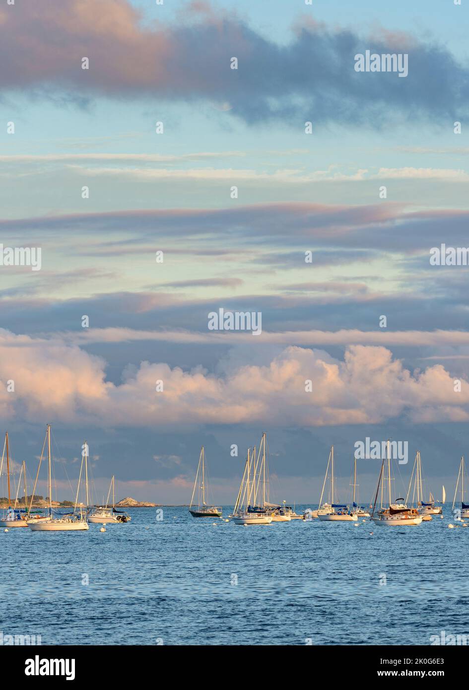 Le nuvole rosa e grigio blu ormeggiano barche a vela al Magic Hour Foto Stock