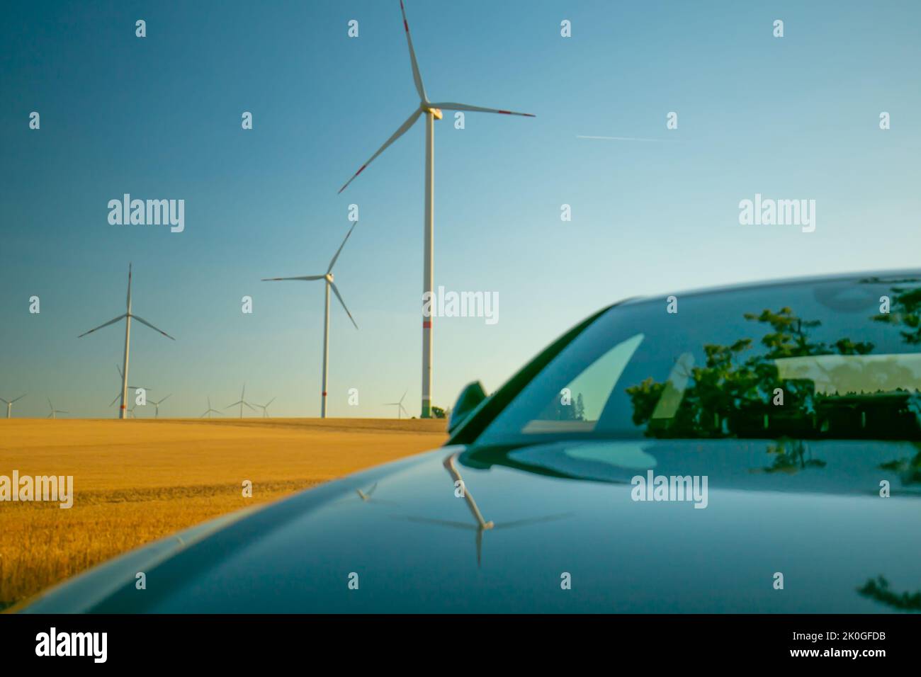 Generatori di vento e auto elettrica nel campo e auto elettrica. Energia alternativa per cars.Wind Energy.Refuelling l'auto con risorse rinnovabili Foto Stock