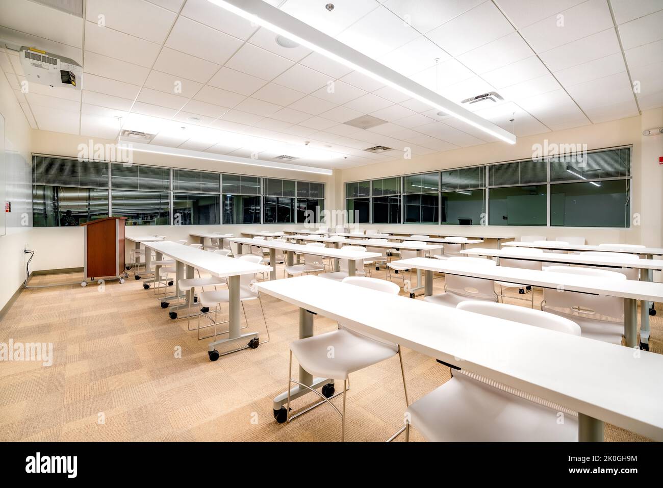 Esempio di una nuova formazione in ufficio vuota e non descrittiva, sala riunioni con scrivanie, sedie e lavagna bianca. La camera potrebbe trovarsi in quasi tutti gli uffici. Foto Stock