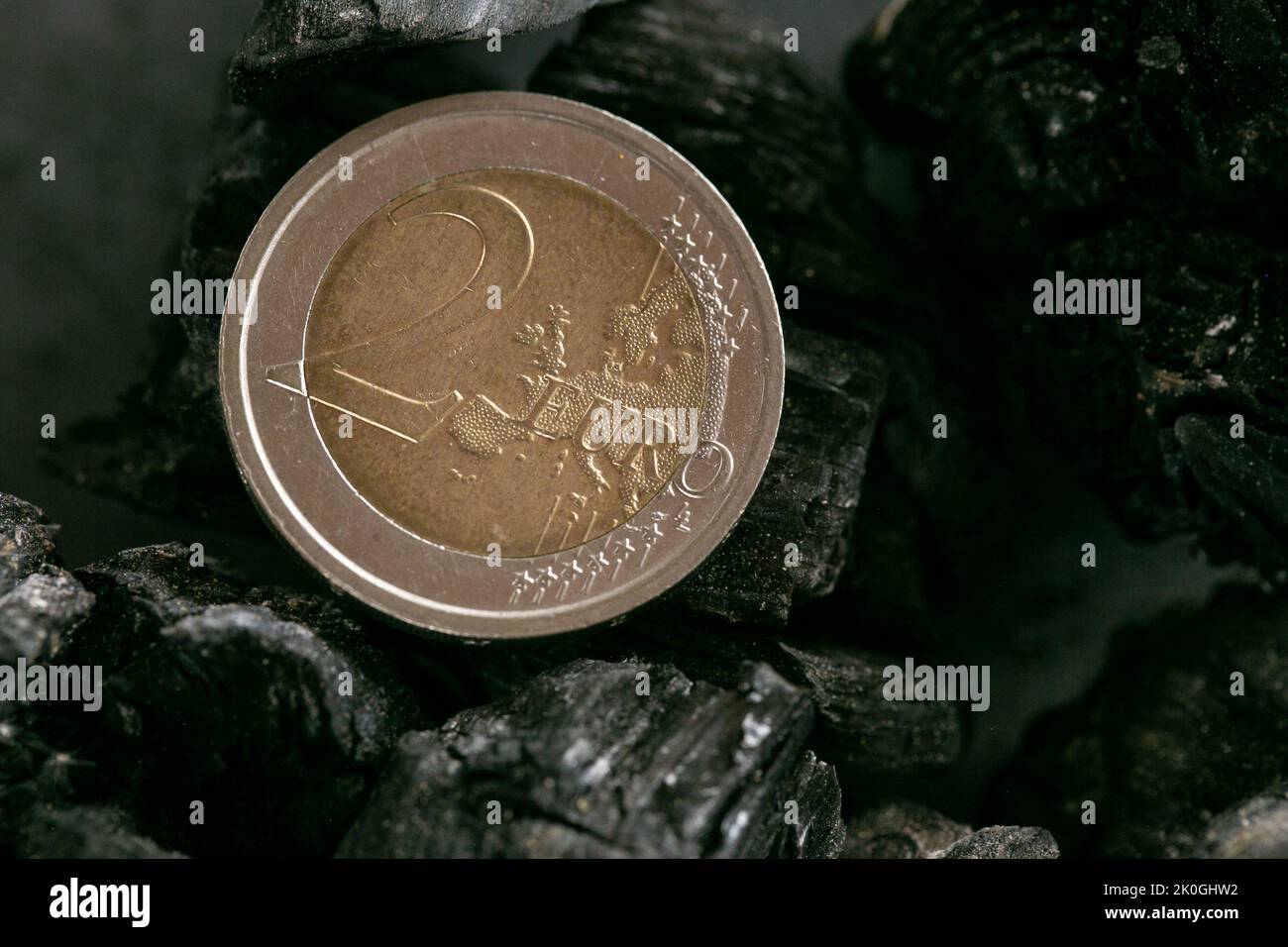 Costo del carbone in Europe.Buying e vendendo coal.Two moneta euro su un pezzo di coal.Heating con carbone Foto Stock