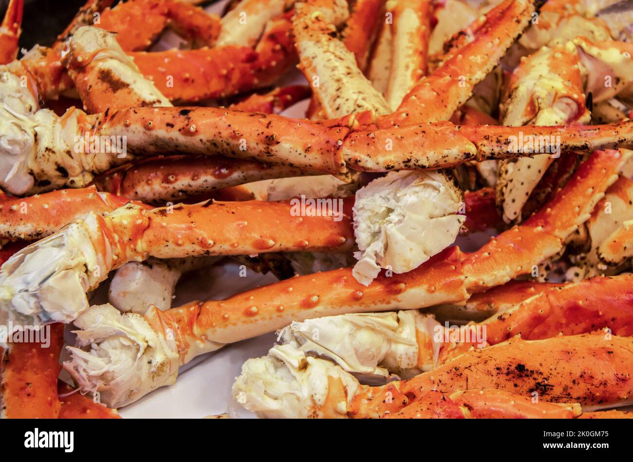 Deliziose gambe di granchio king cotte accumulate su carta macellaio - pronti a mangiare - fuoco selettivo Foto Stock