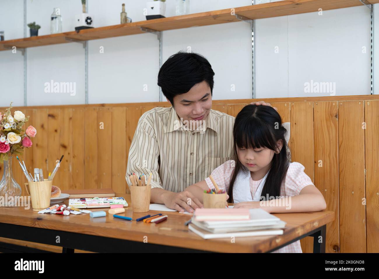 Felice asiatico padre e figlia divertirsi insieme, disegnare e dipingere acquerello. Foto Stock