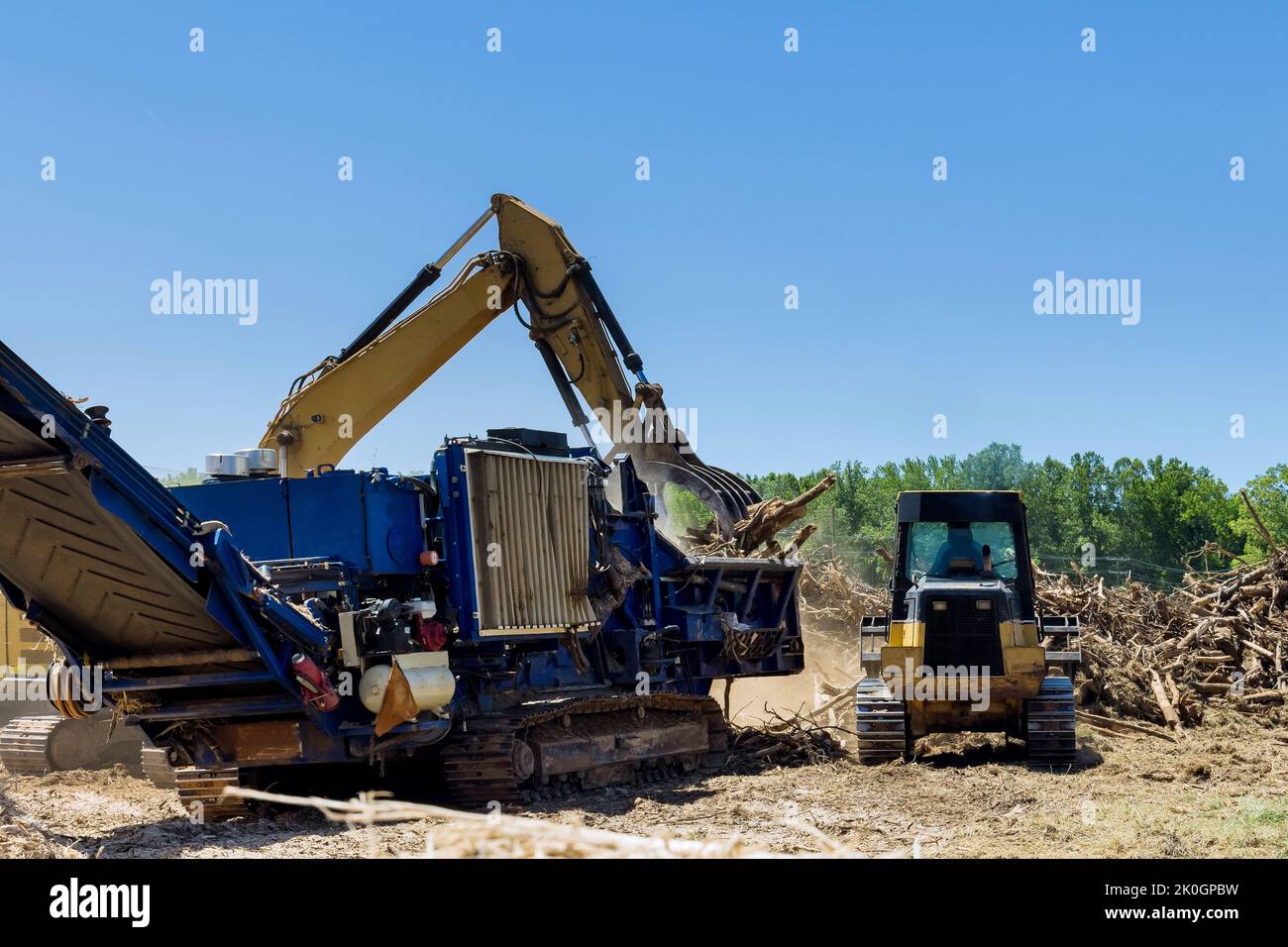 Con l'aiuto di una macchina trituratrice industriale, stiamo distruggendo le radici delle radici sul terreno in preparazione per la costruzione di alloggi Foto Stock