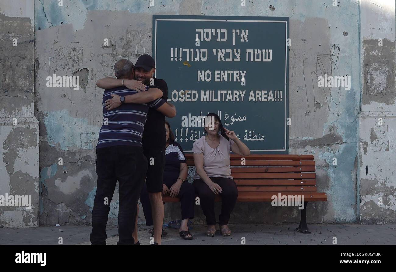 I civili arabi israeliani siedono accanto a un cartello con la scritta "No entry, closed military area” a Jaffa Israel Foto Stock